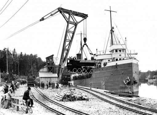S/S NEEBING lastar lok vid "Rysskajen" i Trollhättan. Kranen är byggd på Götaverken och uppsattes våren 1922. Notera rälsen med två olika spårvidder.