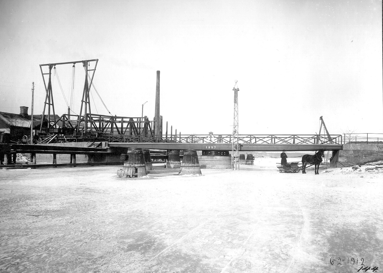 1897 års svängbro över Karls grav. Den ”nya” bron ligger på land och väntar på att få komma på plats. Foto: Annie Wallén, 1912 (Innovatum)